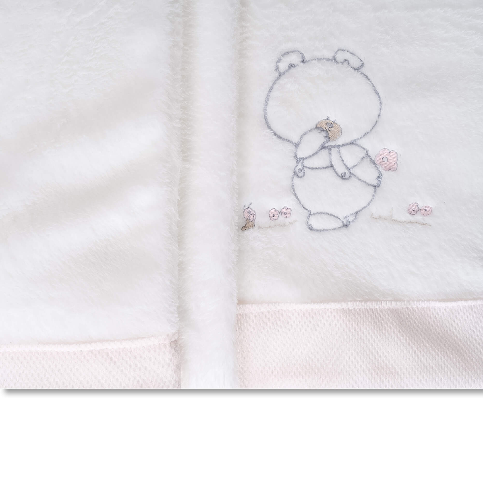 Manta blanca para bebé con borde rosa. Oso de peluche y flores bordados.