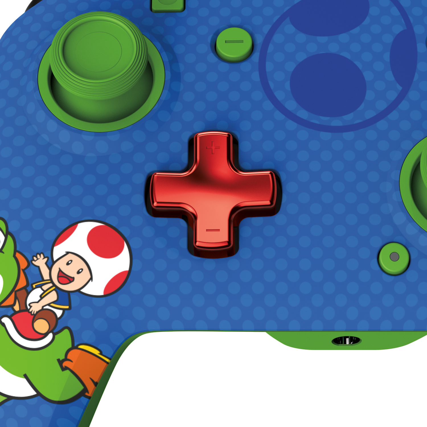 Zbliżenie kontrolera do gier, niebieski korpus z czerwonym krzyżem i zielonym joystickiem oraz Yoshi i Toad.