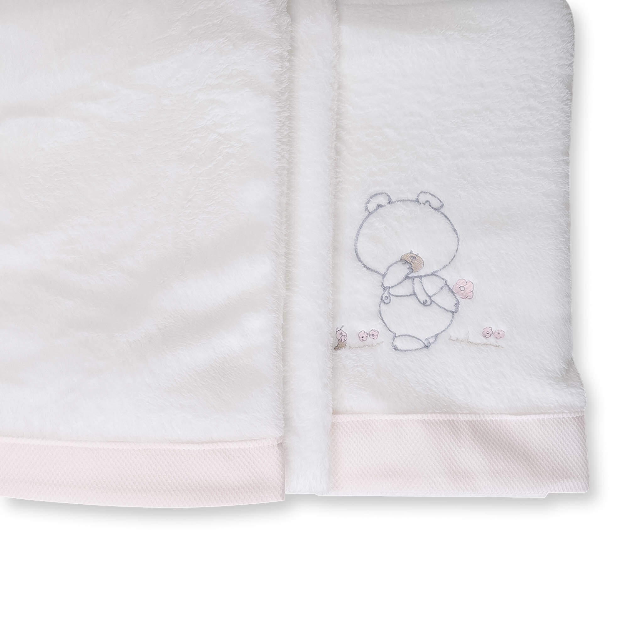 Una manta de bebé blanca con un pequeño bordado de oso de peluche y ribete rosa.