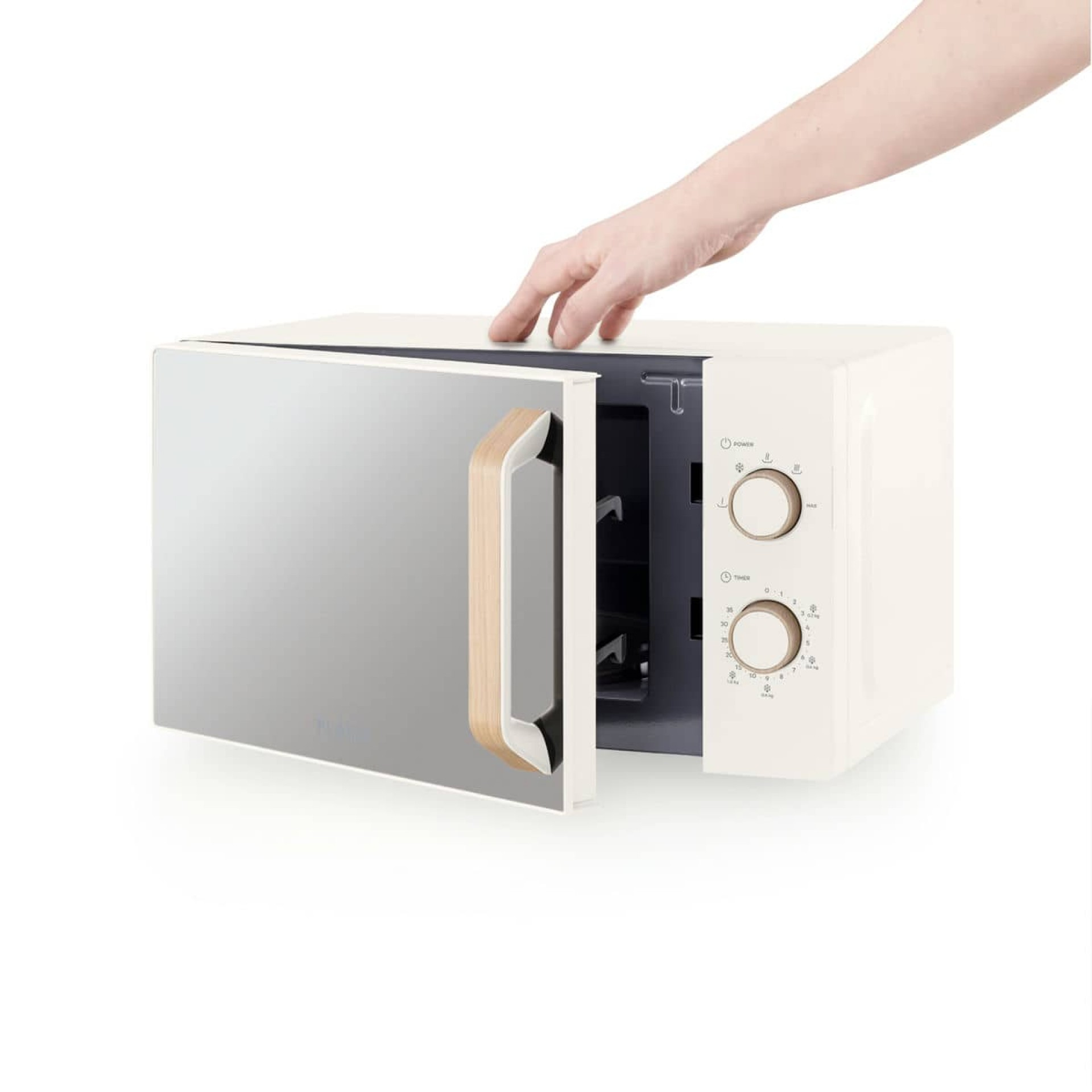 Kremowa kuchenka mikrofalowa, otwarte drzwi. Ręka sięga po otwarcie, widoczny drewniany uchwyt.