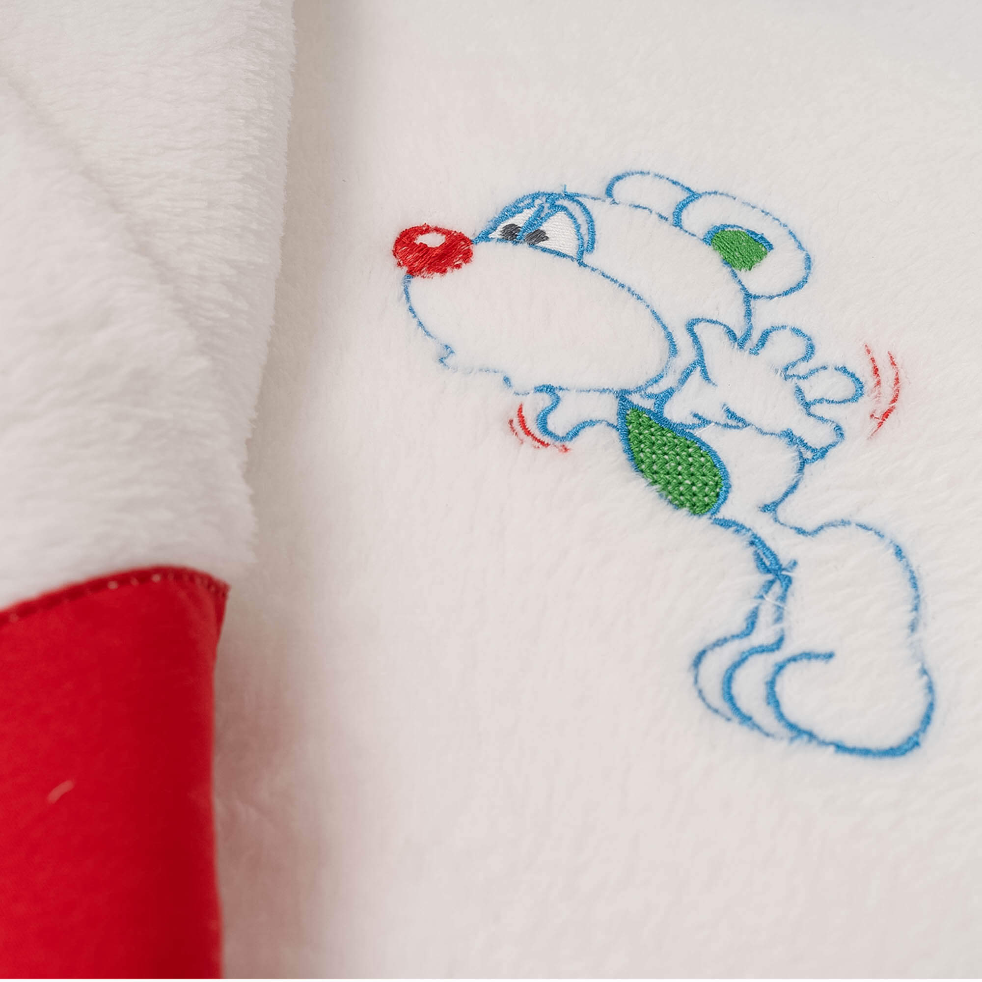 Toalla blanca con bordado de oso de dibujos animados, contorno azul y nariz roja.