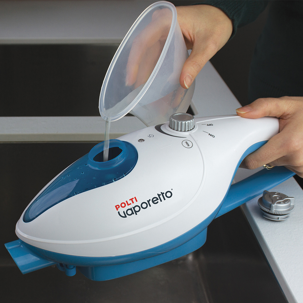 Kobieta wlewa wodę z pojemnika do biało-niebieskiego parownika.