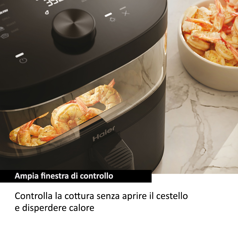 Una friggitrice ad aria nera con gamberetti all'interno, accanto a una ciotola con gamberetti.