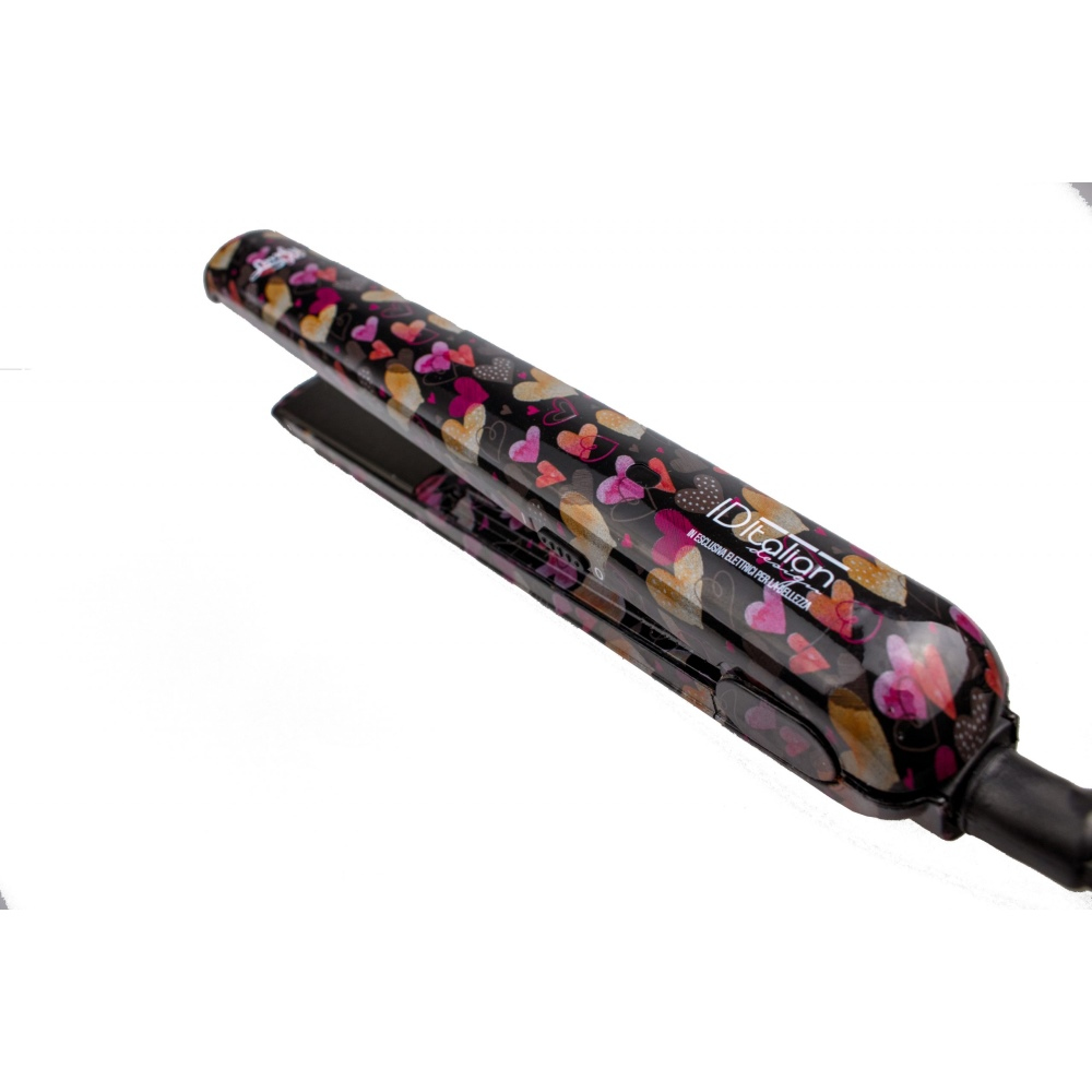 Prostownica do włosów z wzorem serca. Czarna podstawa z kolorowymi sercami. Rączka jest czarna.