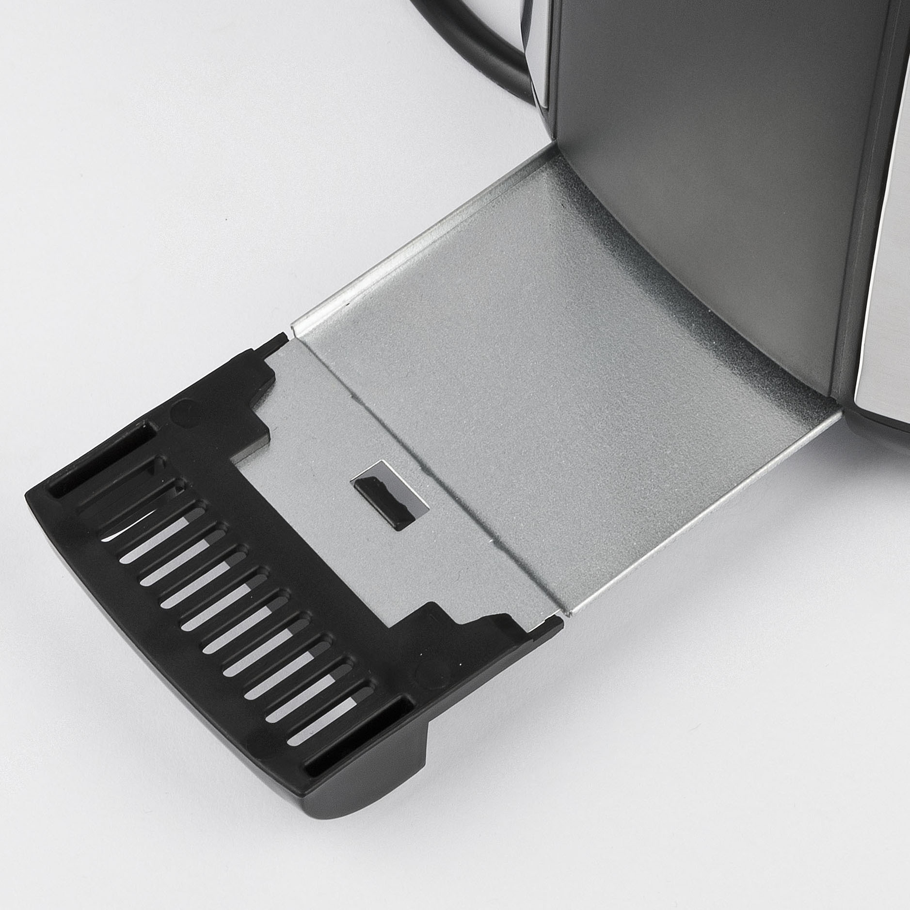Nahaufnahme der Krümelschublade eines Toasters. Silber mit schwarzem Kunststoffrand.