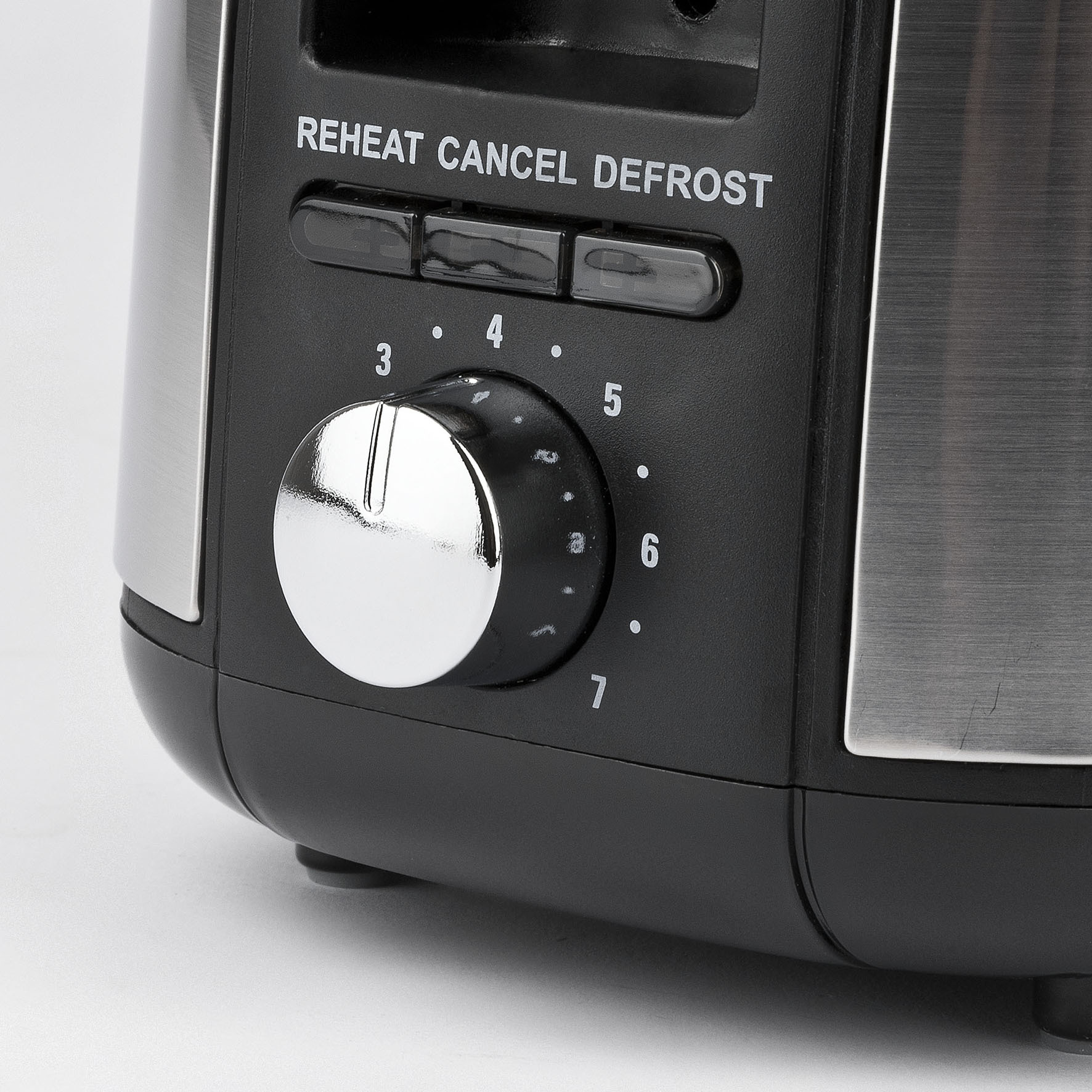 Nahaufnahme eines Toasters mit Bedienelementen für Aufwärmen, Abbrechen, Auftauen und Bräunungsregler.
