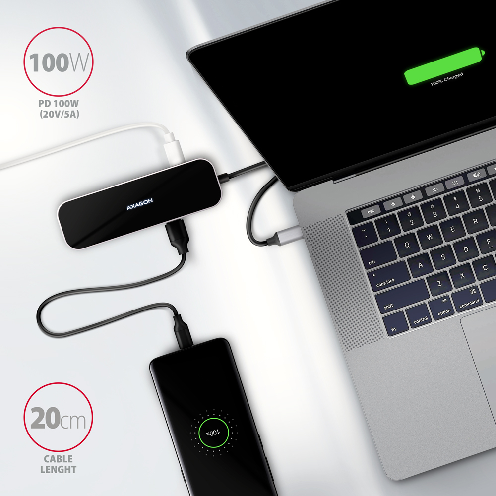 Schwarzer Hub mit Laptop und Handy verbunden, lädt. Weißes Kabel, schwarzer Hintergrund.