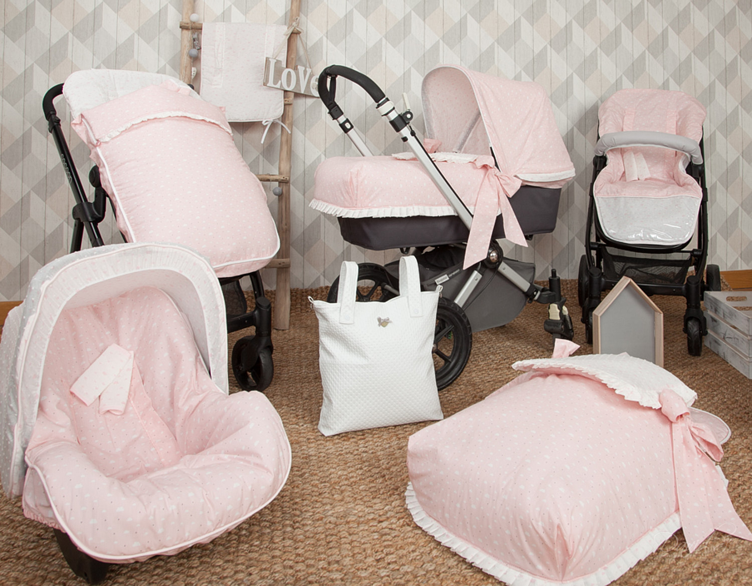 Juego de cochecito rosa para bebé con varios artículos, incluyendo un cochecito, un asiento de coche y un bolso de pañales, todo en rosa.