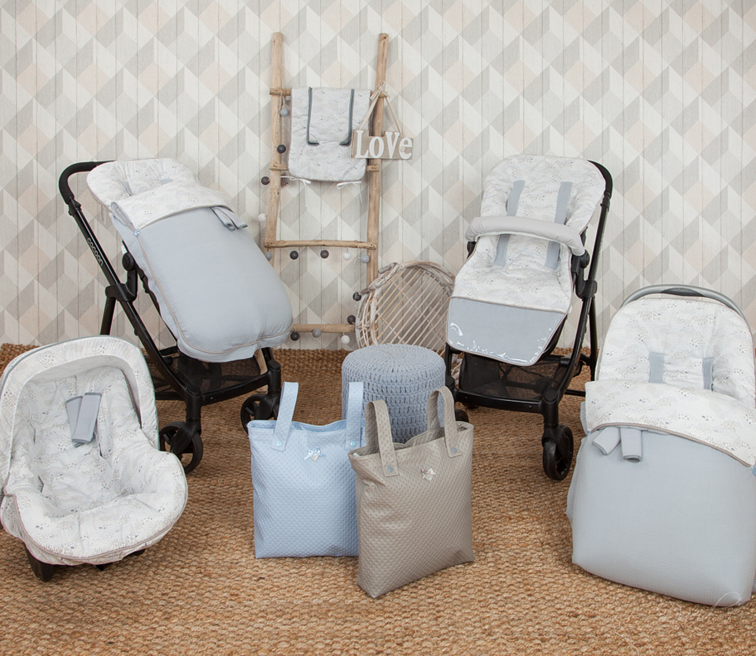 Juego de artículos para bebés: cochecito, asiento de coche, bolsos. Gris, azul claro y blanco. Alfombra beige.