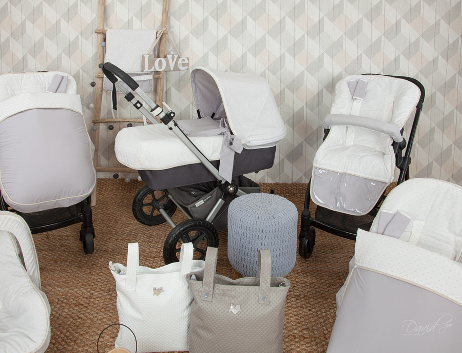Varios accesorios para cochecitos de bebé en blanco y gris están expuestos.