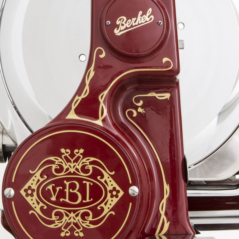 Eine dekorative Seitenverkleidung eines rot-goldenen Fleischschneiders mit Marken- und Designdetails.