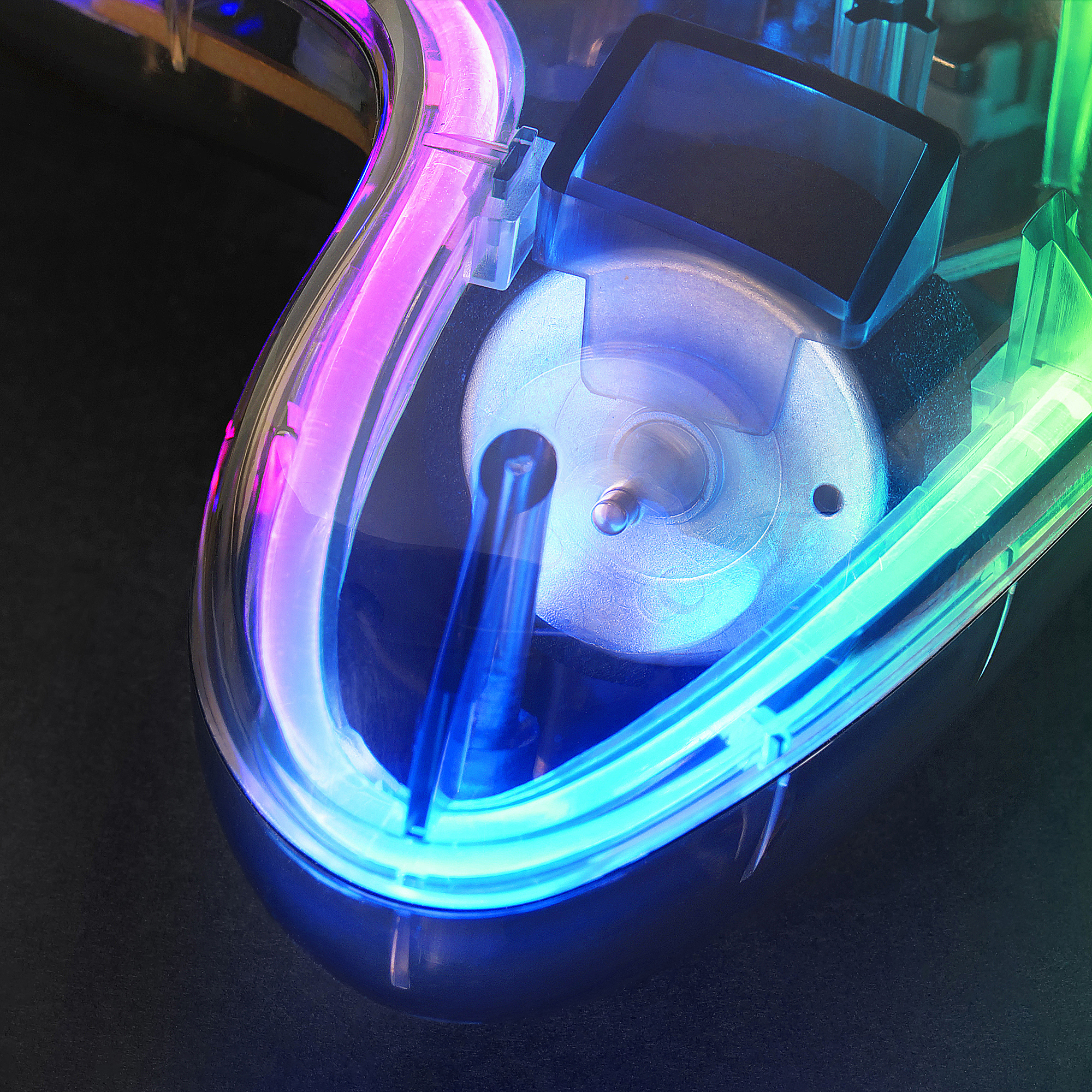 Zbliżenie myszy z podświetlanymi kolorami tęczy i przezroczystą obudową.