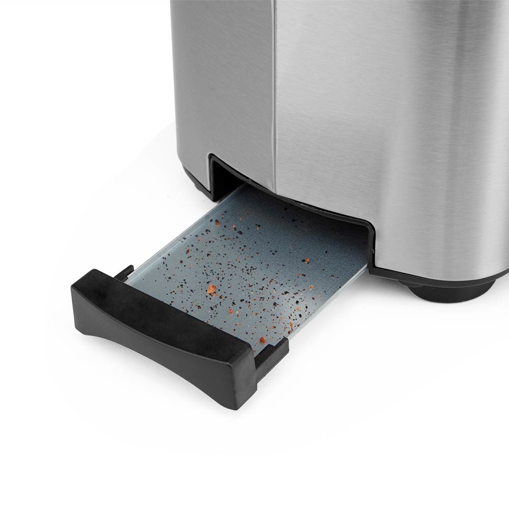 Zbliżenie tacy na okruchy tostera. Jest srebrna z czarnym uchwytem, ​​pokazującym okruchy.