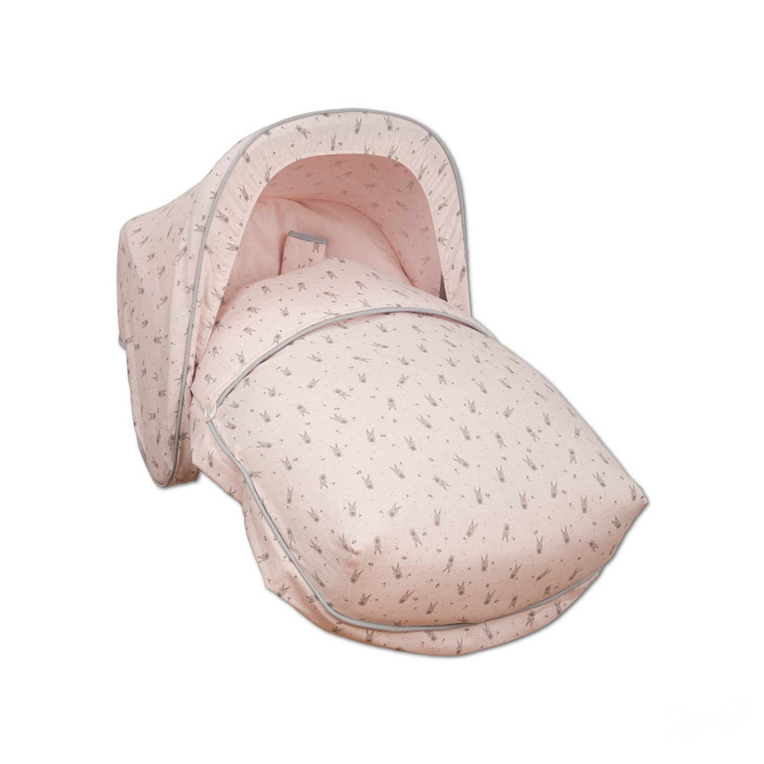 Una cuna para bebé rosa con un patrón de puntos grises, sobre un fondo blanco. Tiene una cubierta.