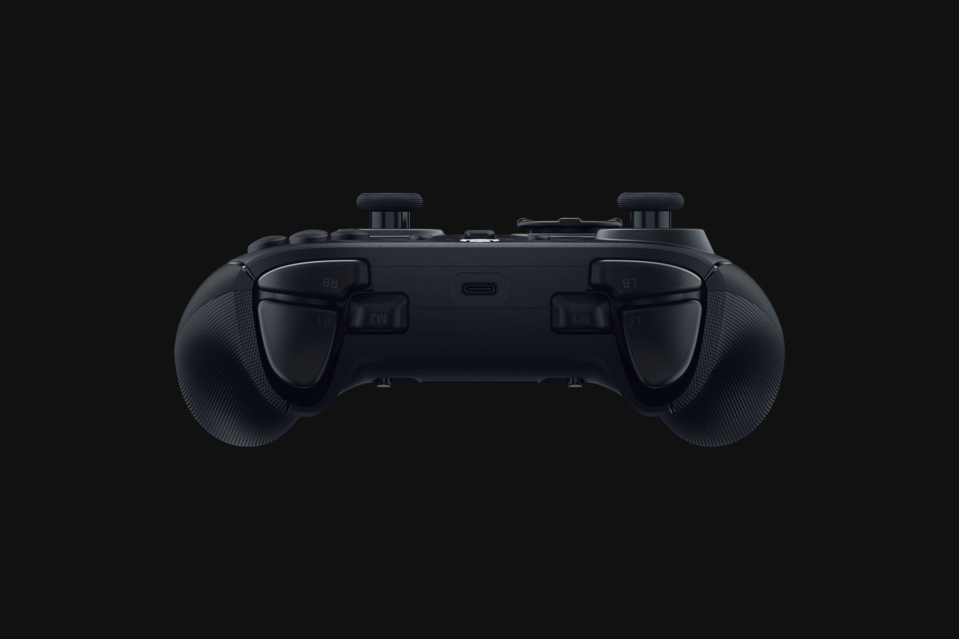 Czarny kontroler do gier widziany od dołu. Widoczne są przyciski i joysticki.