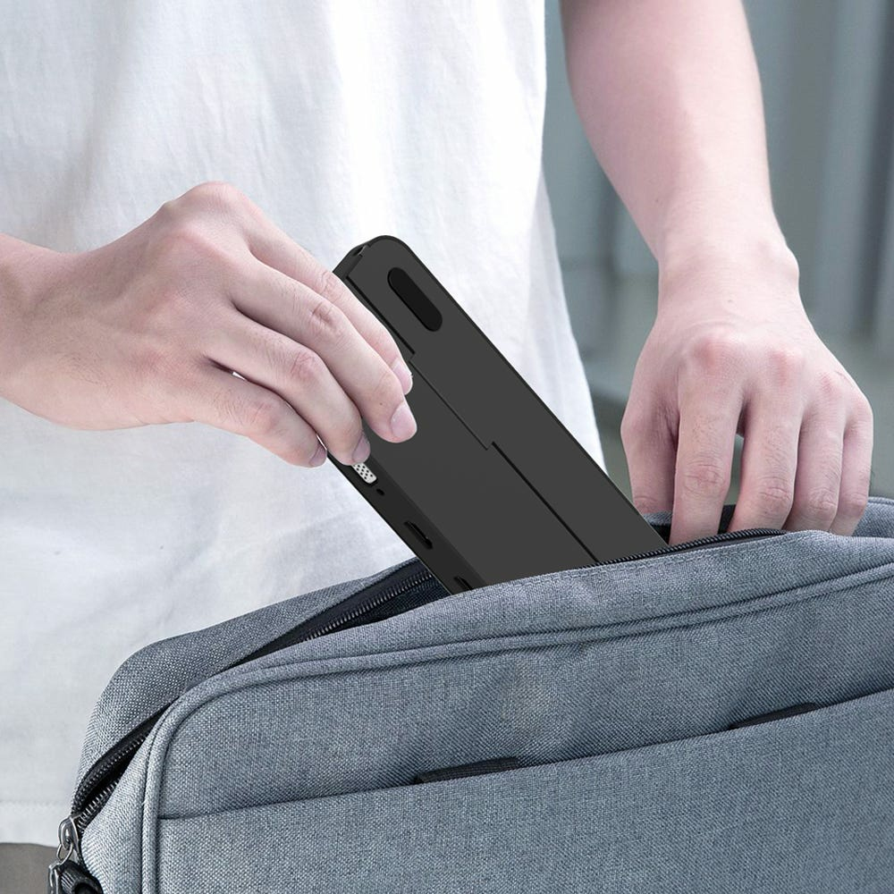 Ein schwarzes Gehäuse mit einem Tablet darin wird in eine graue Tasche gesteckt.