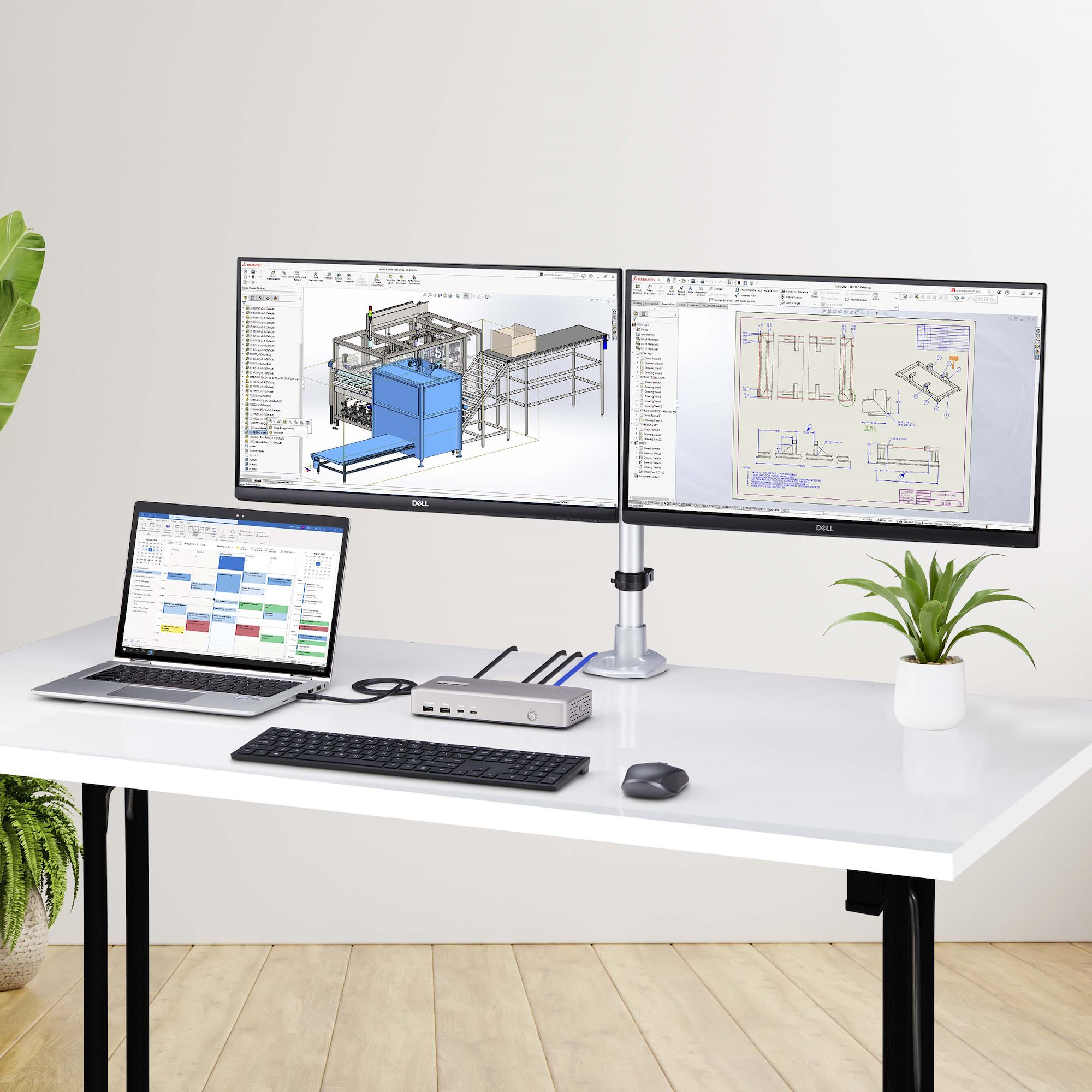 Espace de travail avec deux moniteurs, ordinateur portable, clavier, souris et plante.