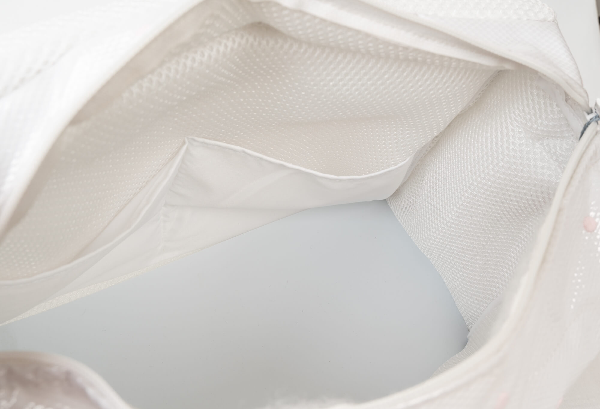 Dentro de una bolsa de malla blanca con bolsillos.