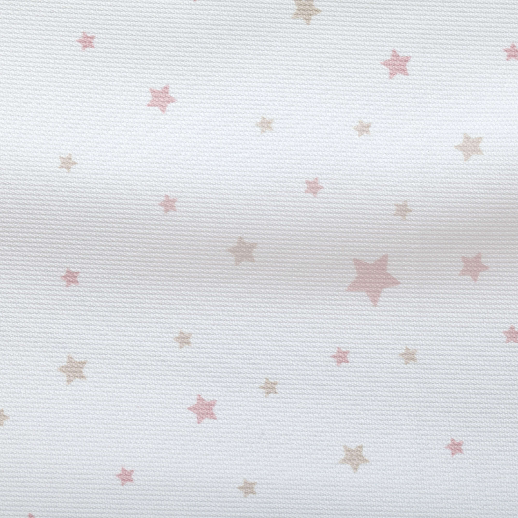 Primer plano de un textil blanco con pequeñas estrellas rosas y beige.