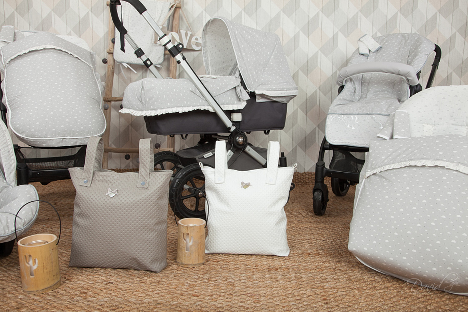 Juego de equipo para bebés, incluyendo cochecito y bolsas, en una combinación de colores gris y blanco.