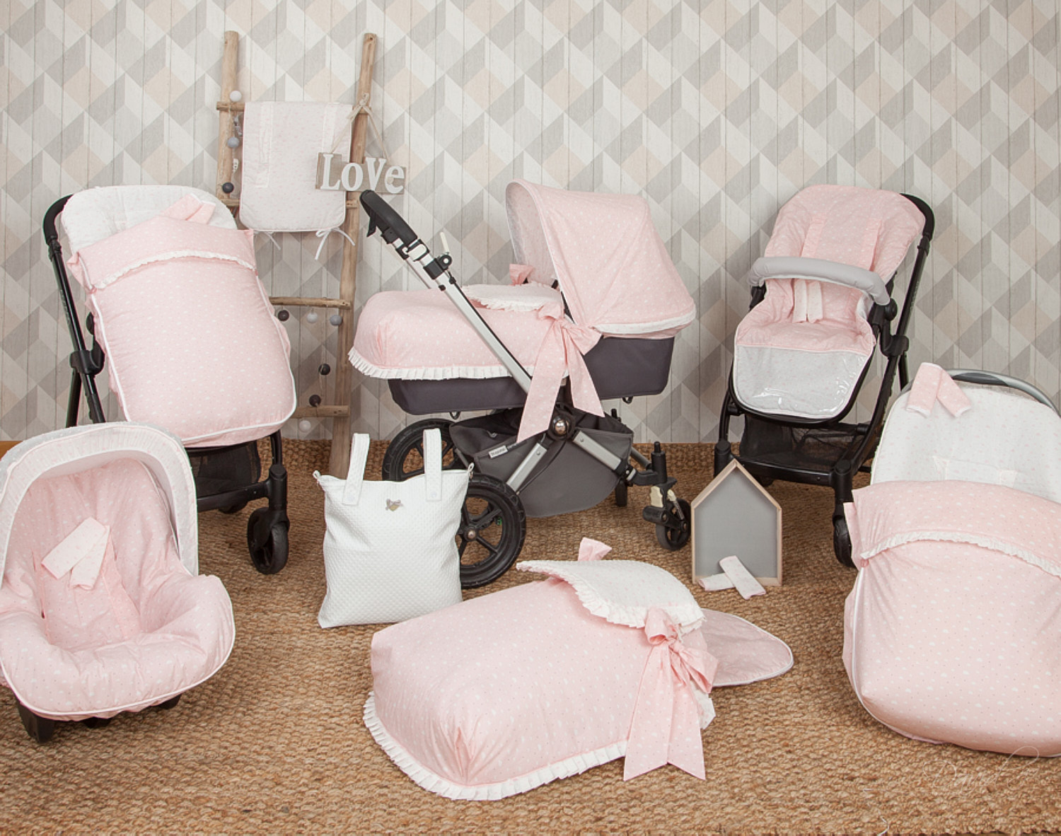 Productos para bebés en un ambiente. Tema rosa y blanco. Incluye cochecito, bolso y más.