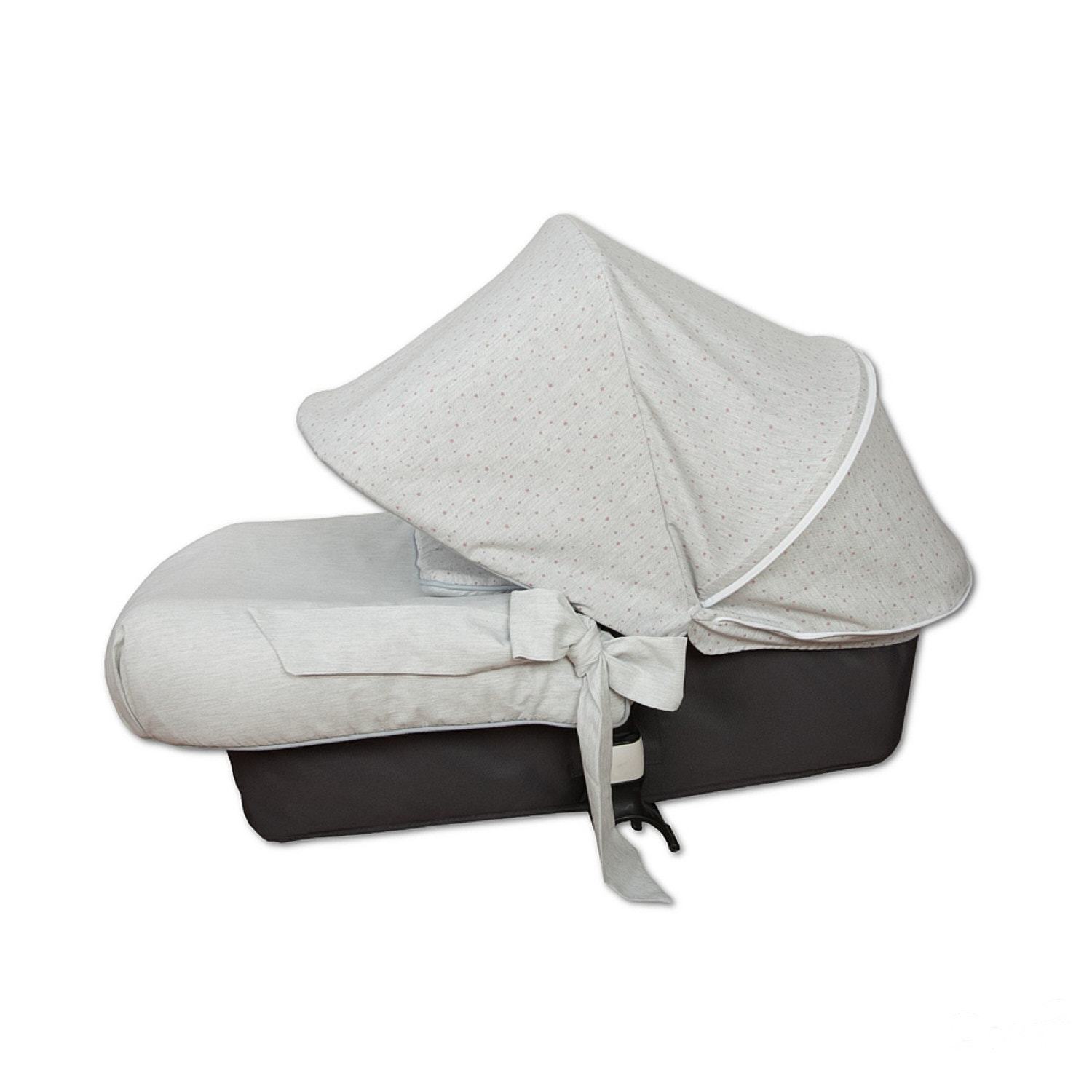 Una cuna para bebés con un dosel gris claro con lunares. Tiene un colchón a juego y una base gris oscuro.