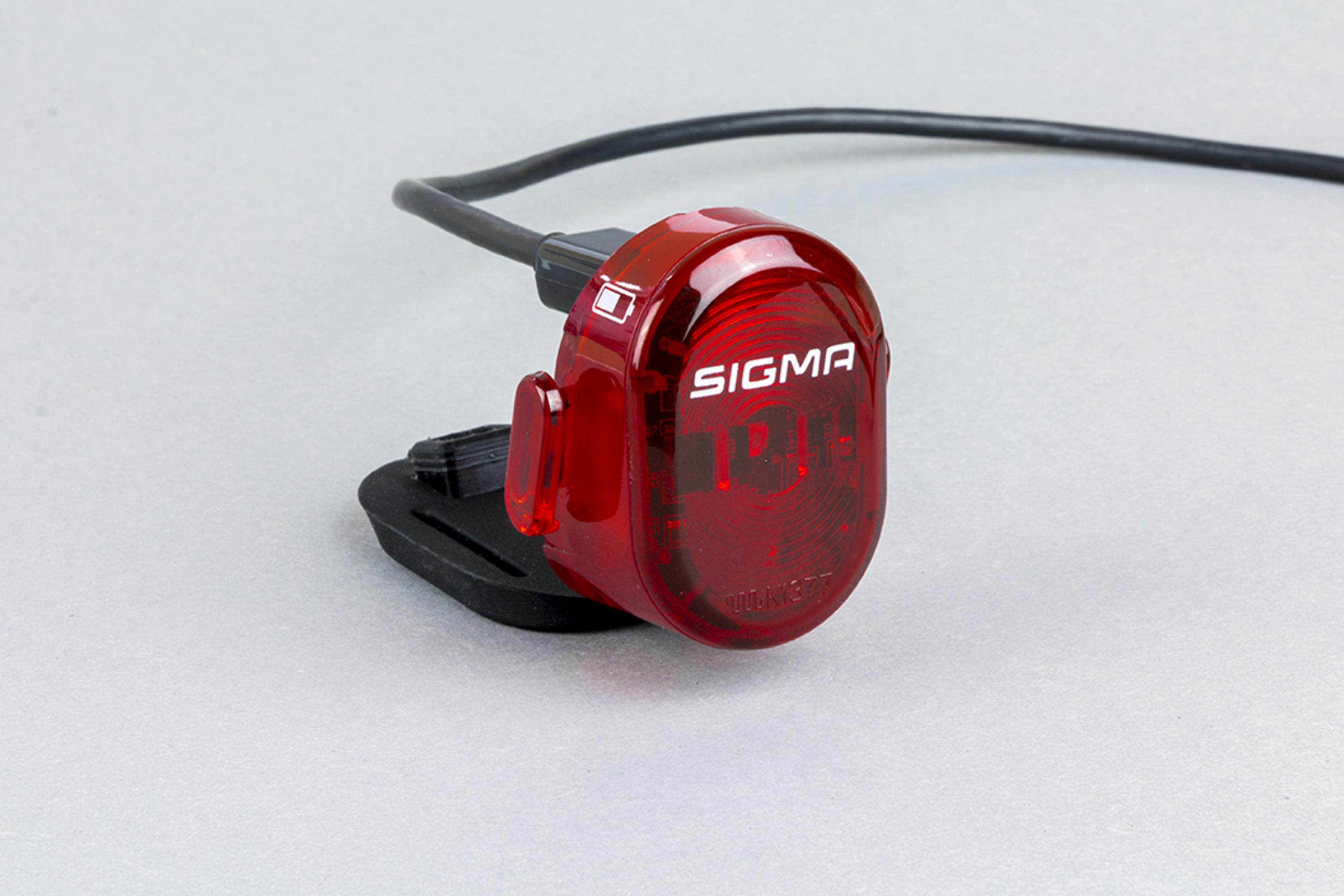 Czerwone i czarne światło rowerowe z kablem USB, z napisem 'SIGMA' i wskaźnikiem baterii.
