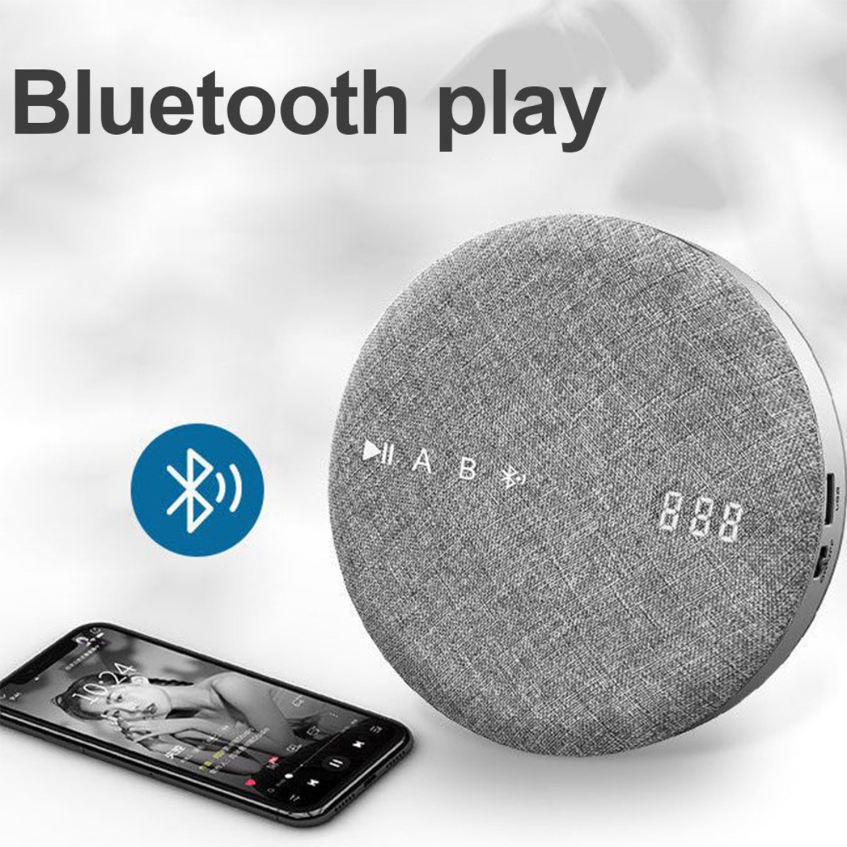 Ein grauer Bluetooth-Lautsprecher und ein Smartphone, das eine Musik-App-Oberfläche anzeigt.