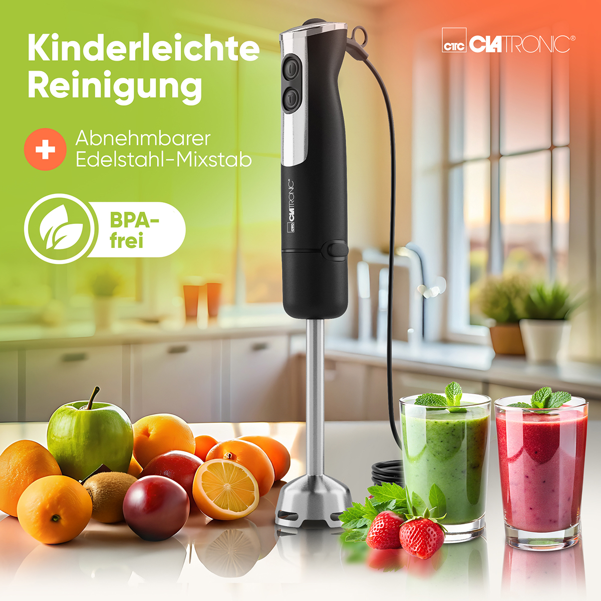 Ein schwarzer Stabmixer mit Früchten, Gemüse und zwei Smoothie-Gläsern auf weißem Hintergrund.