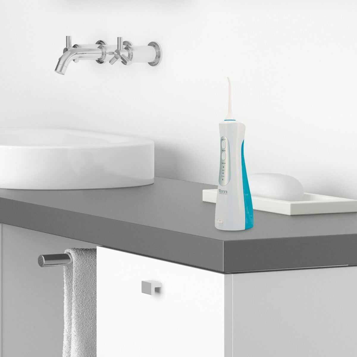 Ein weißer und tealfarbener Wasserflosser auf einer grauen Arbeitsplatte neben einem Waschbecken und Wasserhahn.