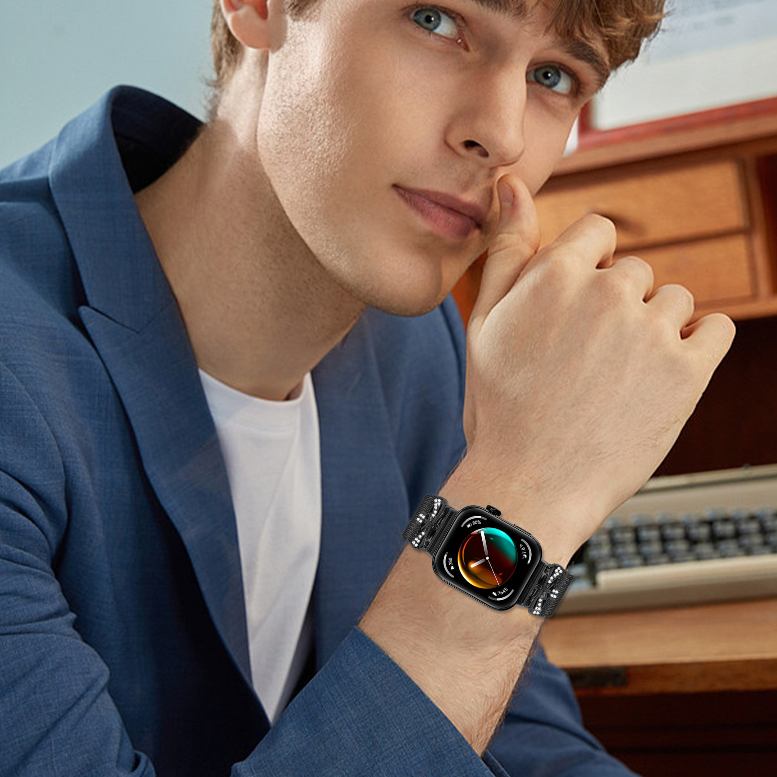 Uomo in completo blu, polso con smartwatch nero, che si tocca il viso.