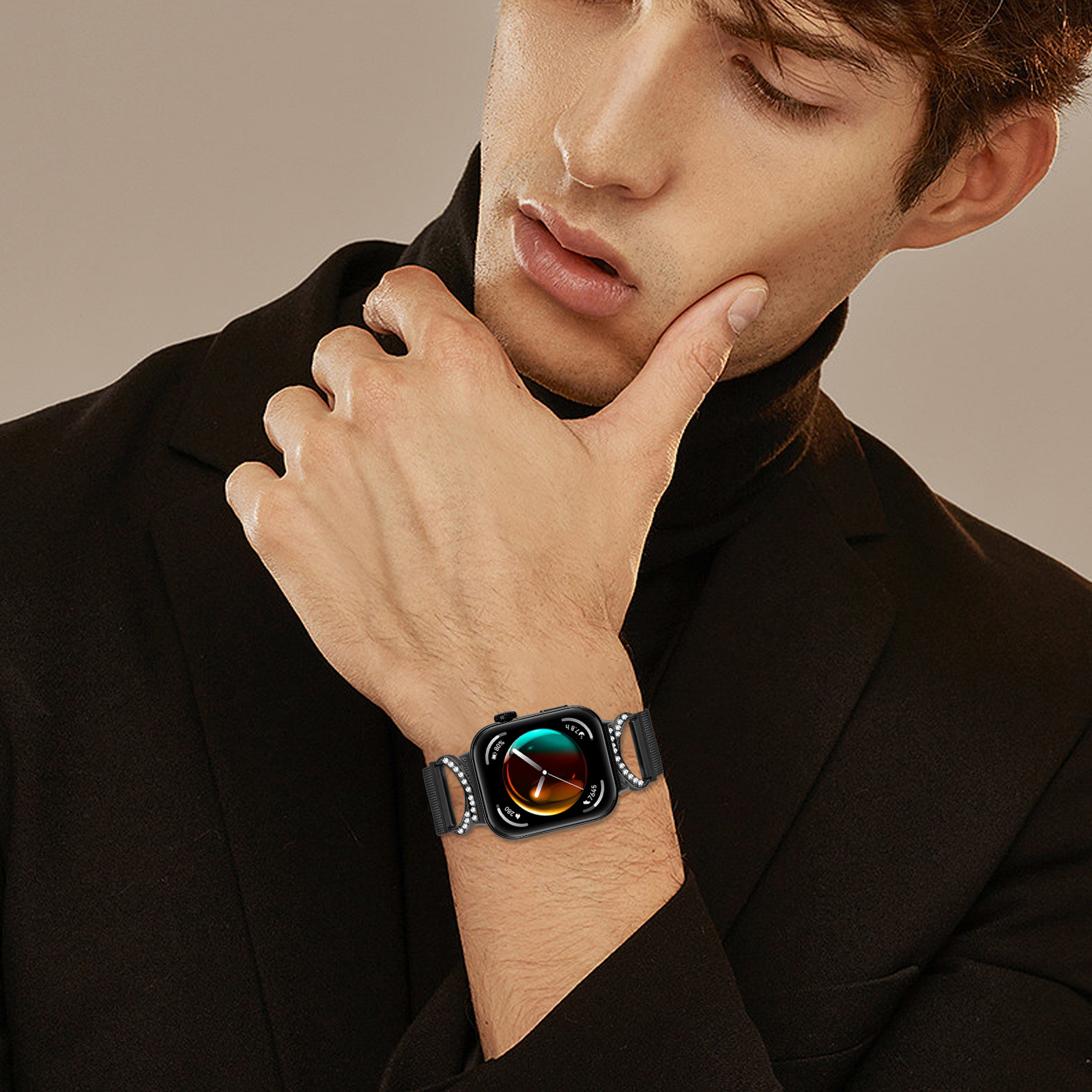 Ein Mann trägt einen schwarzen Rollkragenpullover und eine Uhr mit schwarzem Armband und Zifferblatt.
