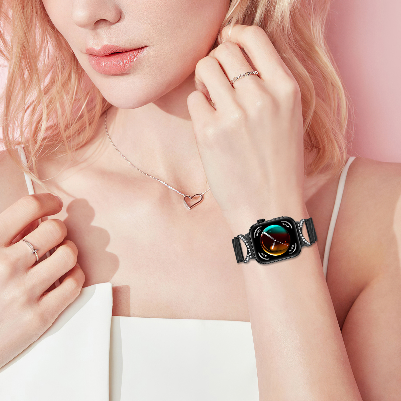 Handgelenk einer Frau mit schwarzer Uhr. Armband ist schwarz mit vierblättrigem Kleeblatt-Design und Strasssteinen.