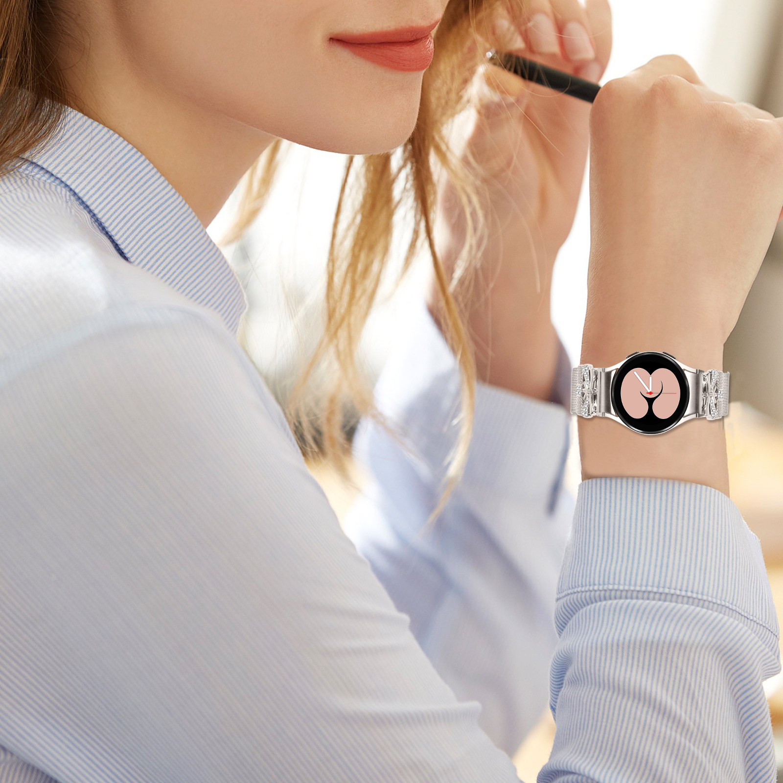 Frau mit Smartwatch. Silbernes Armband, rosa Herzsymbol auf dem Bildschirm, blaues Hemd.