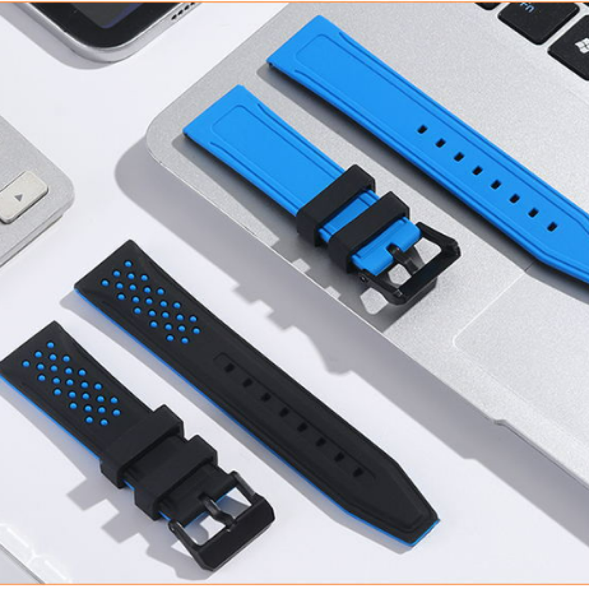 Cinturini: blu e neri con fibbie, appoggiati su un laptop.