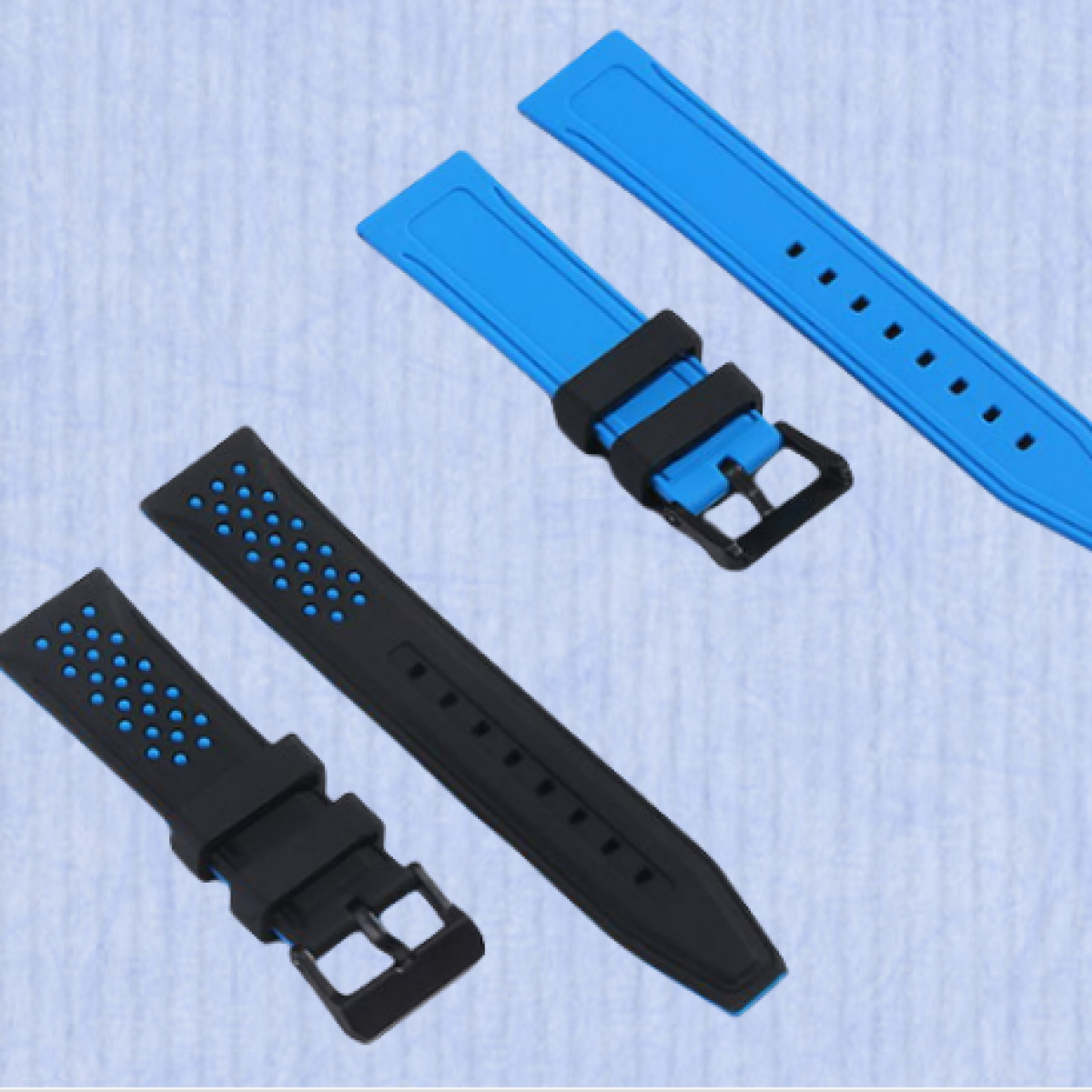 Cinturini per orologi neri e blu, su sfondo azzurro. Fibbie visibili.