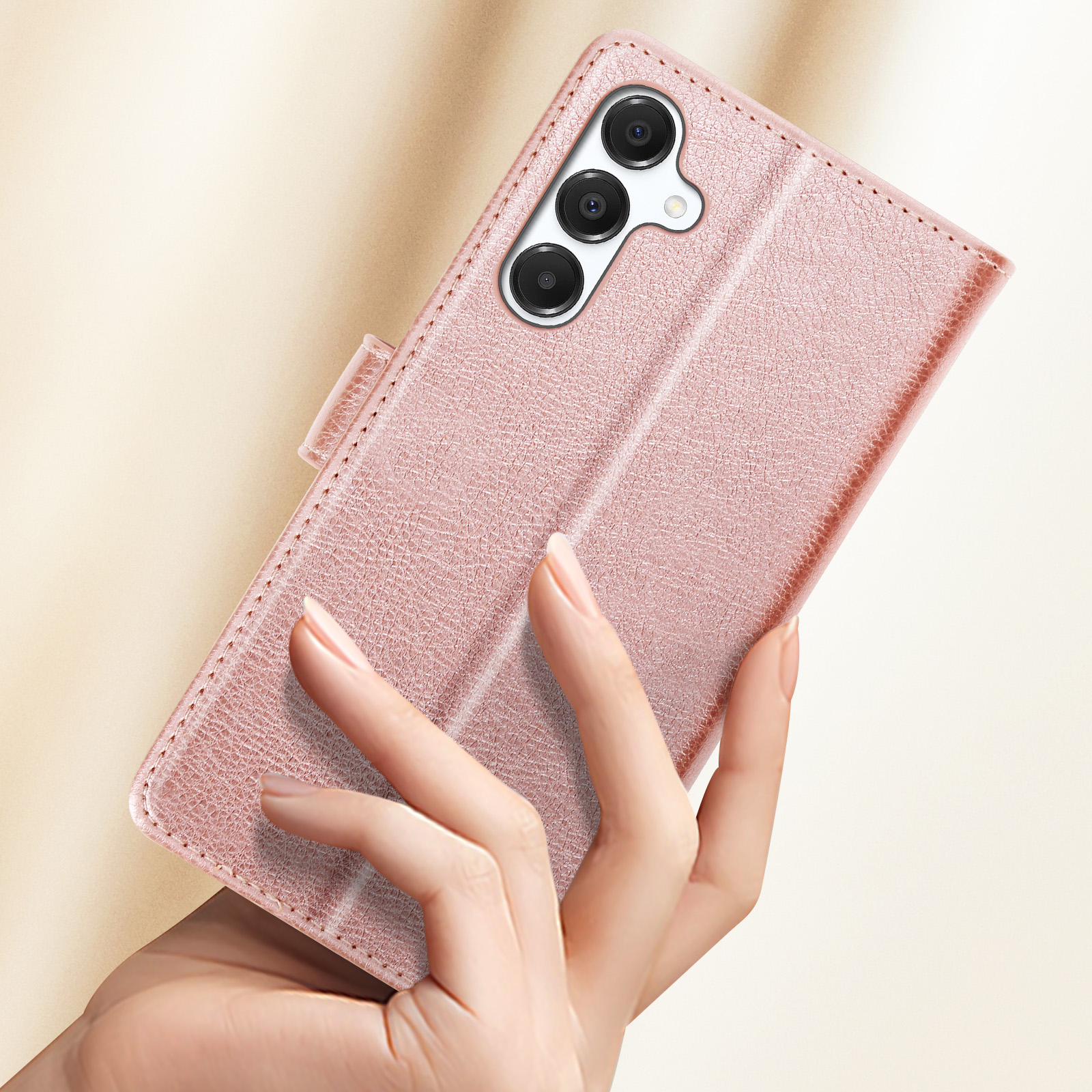 Una custodia per telefono rosa tenuta in una mano. Ha un ritaglio per la fotocamera e una chiusura magnetica.