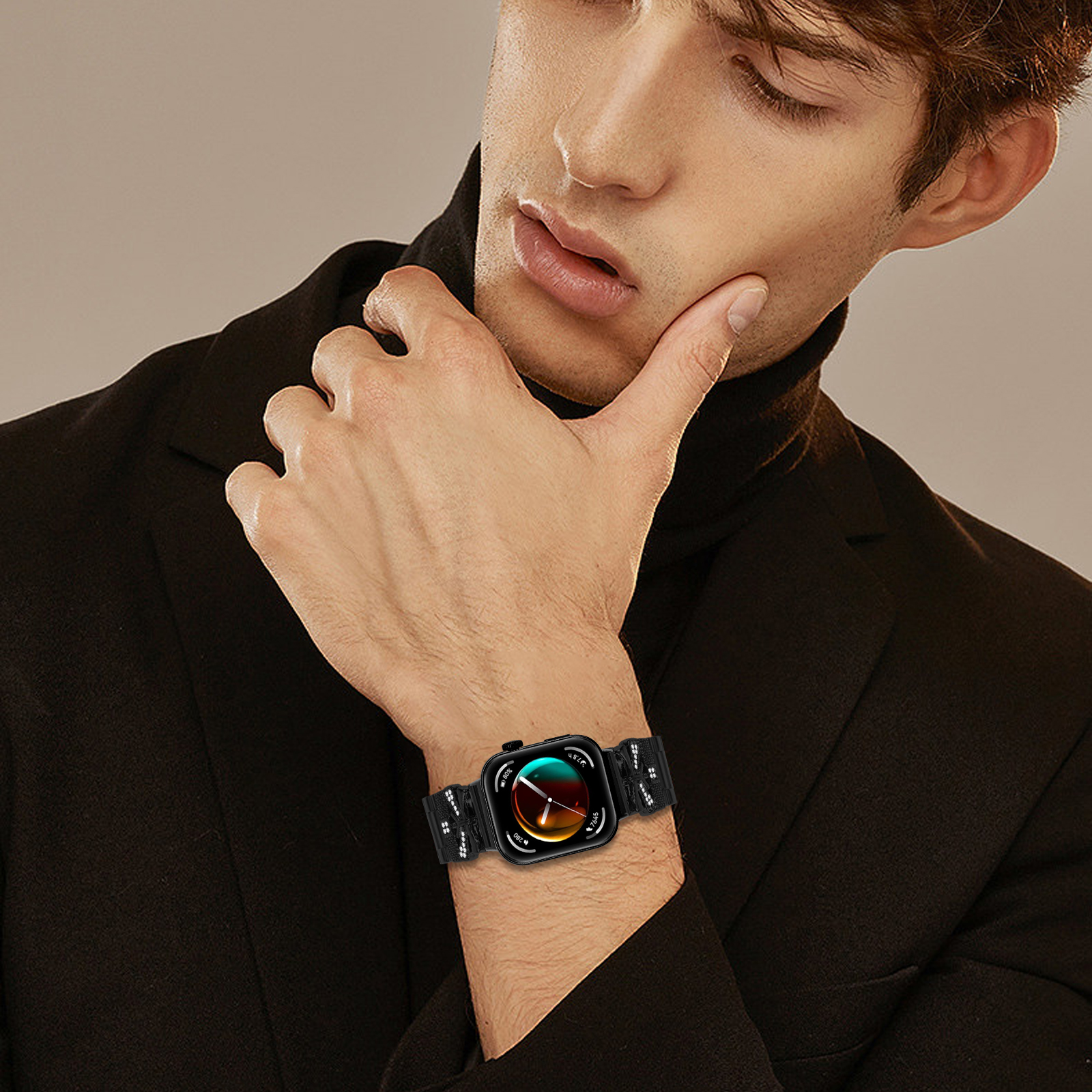 Un uomo con un abito nero e uno smartwatch, che guarda il suo polso. L'orologio mostra un display colorato.