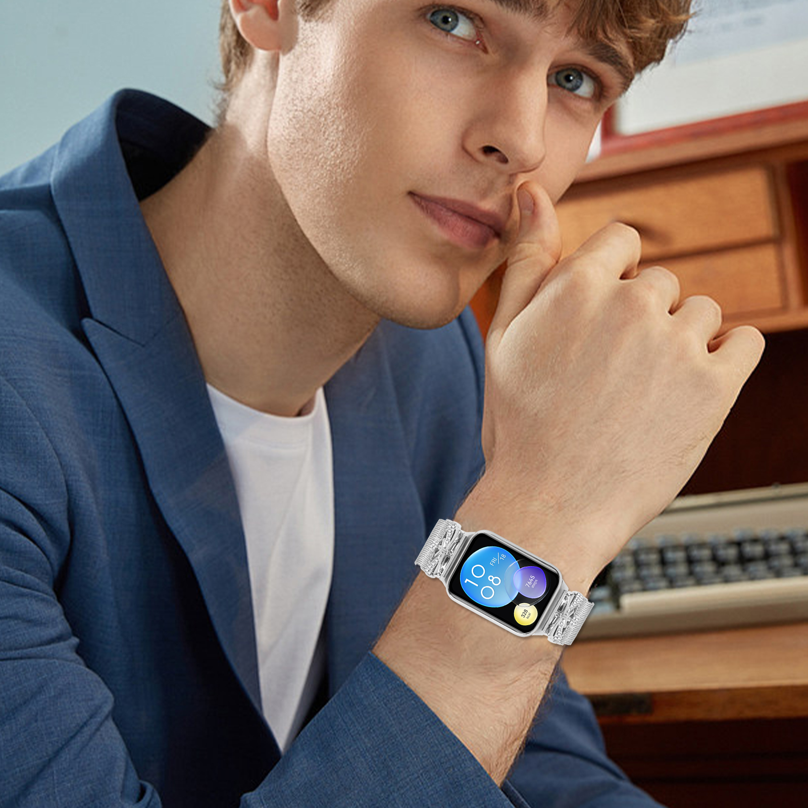Uomo con giacca blu e orologio con cassa argentata. L'orologio mostra ora e data, al chiuso.