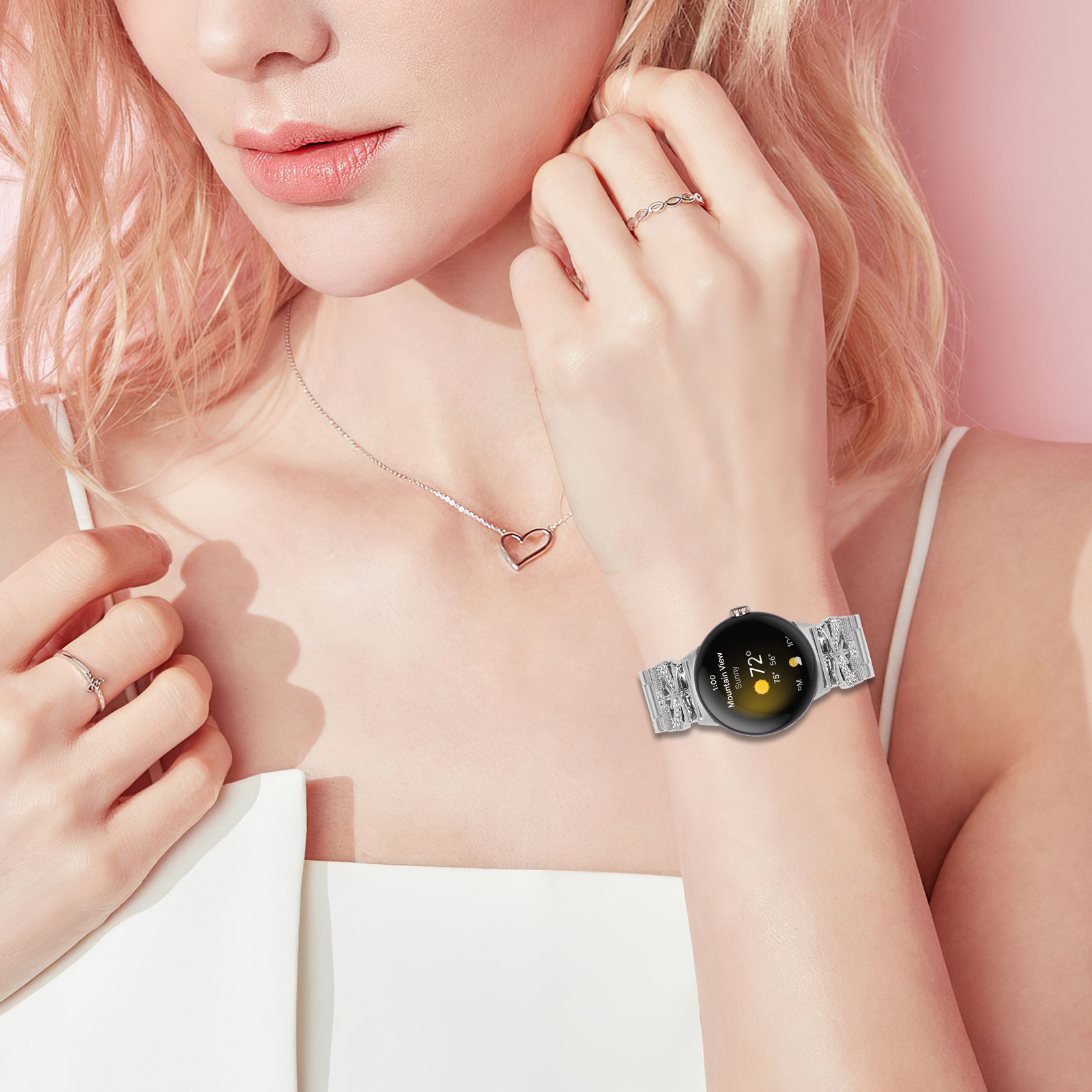 Das Handgelenk einer Frau mit einer silbernen Uhr, Halskette und Ringen. Die Uhr zeigt Zeit und Wetter.
