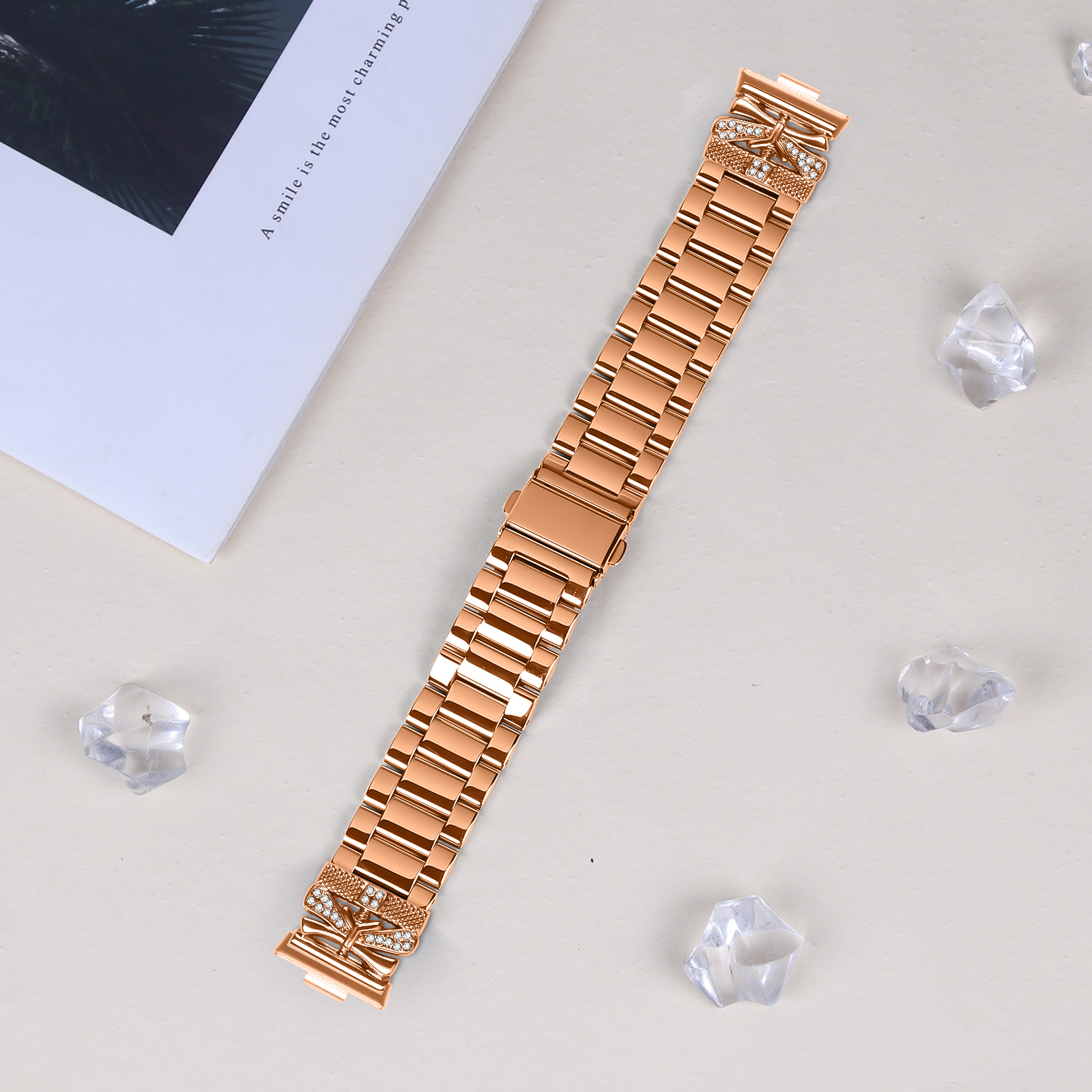 Un cinturino per orologio in oro rosa con design a libellula e cristalli trasparenti.