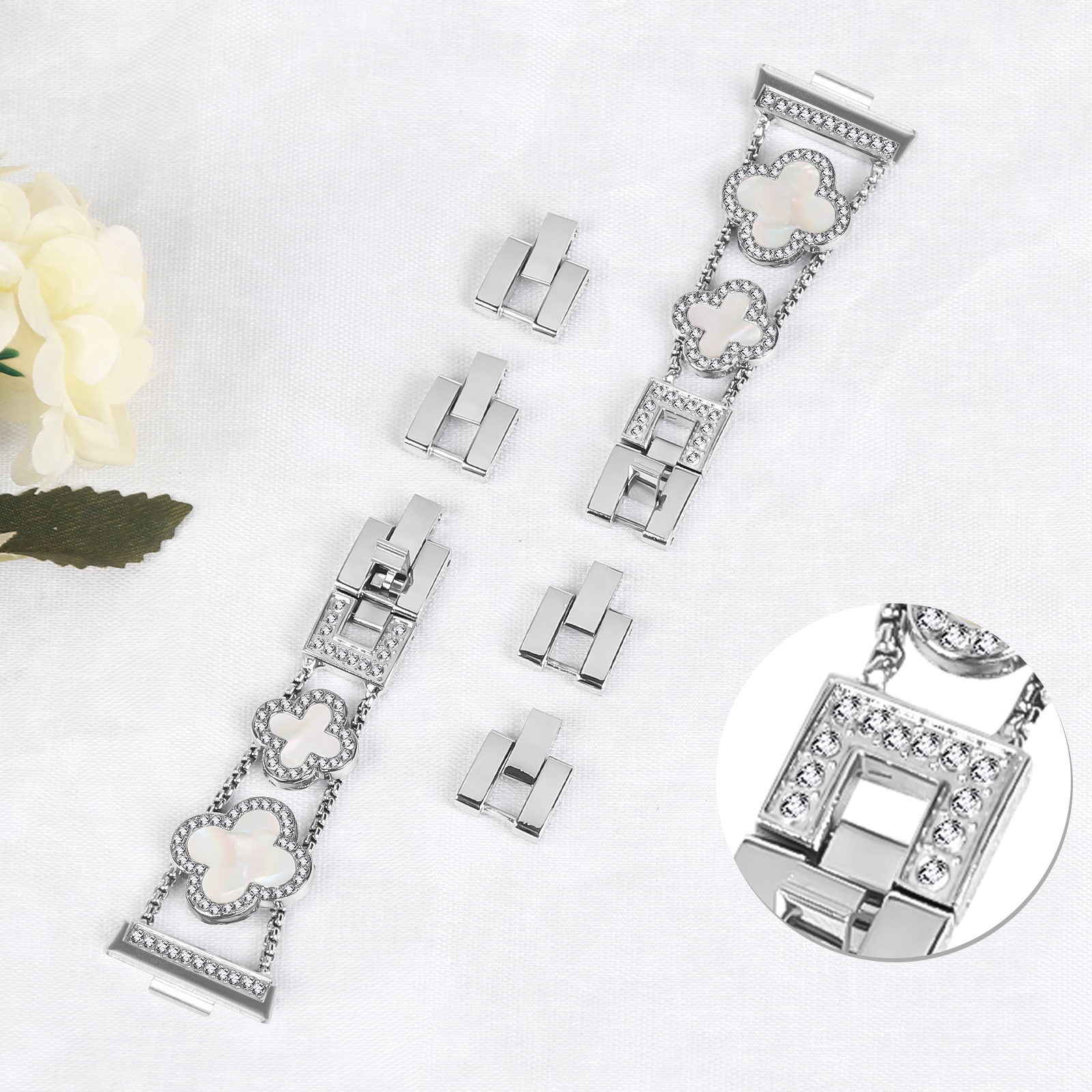 Silbernes Uhrenarmband mit Kleeblatt- und Diamantmustern und zusätzlichen Gliedern.