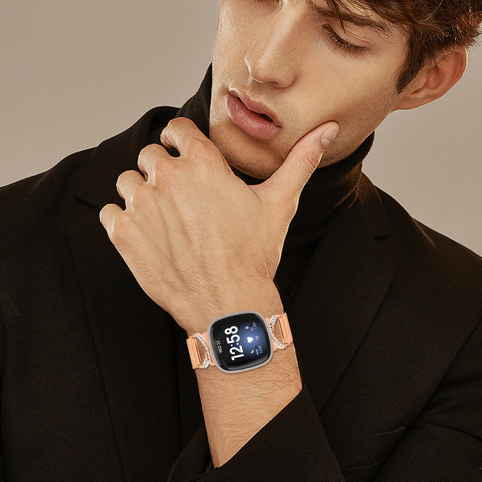 Ein Mann mit schwarzem Rollkragen betrachtet eine Smartwatch an seinem Handgelenk. Die Uhr ist hell.