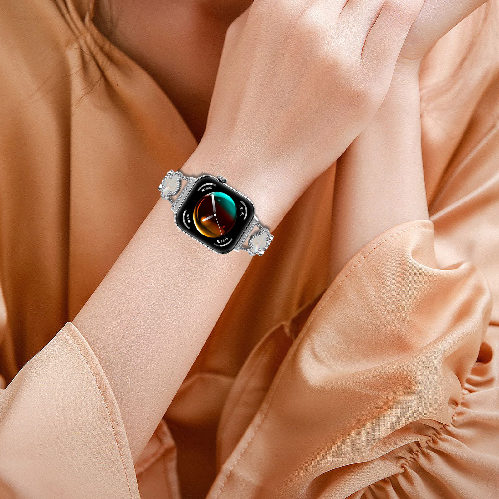 Person trägt Smartwatch mit silbernem Armband, mit farbenfrohem Display, am Handgelenk, Hand auf Hand.