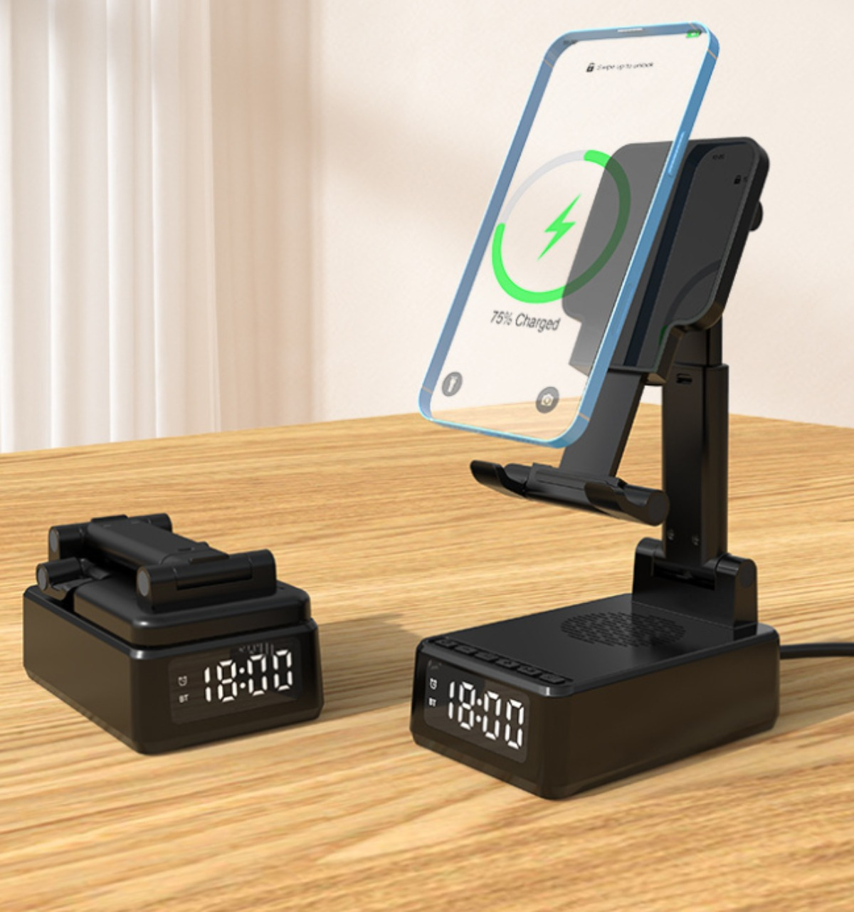Ein schwarzes kabelloses Ladegerät mit Telefon und Uhr auf Holztisch.