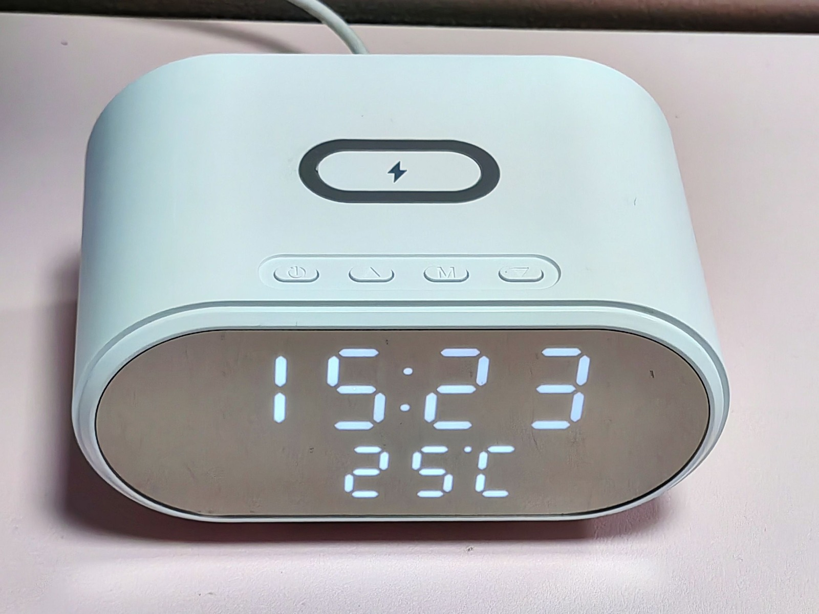 Ein weißer digitaler Wecker, der die Uhrzeit und Temperatur anzeigt.