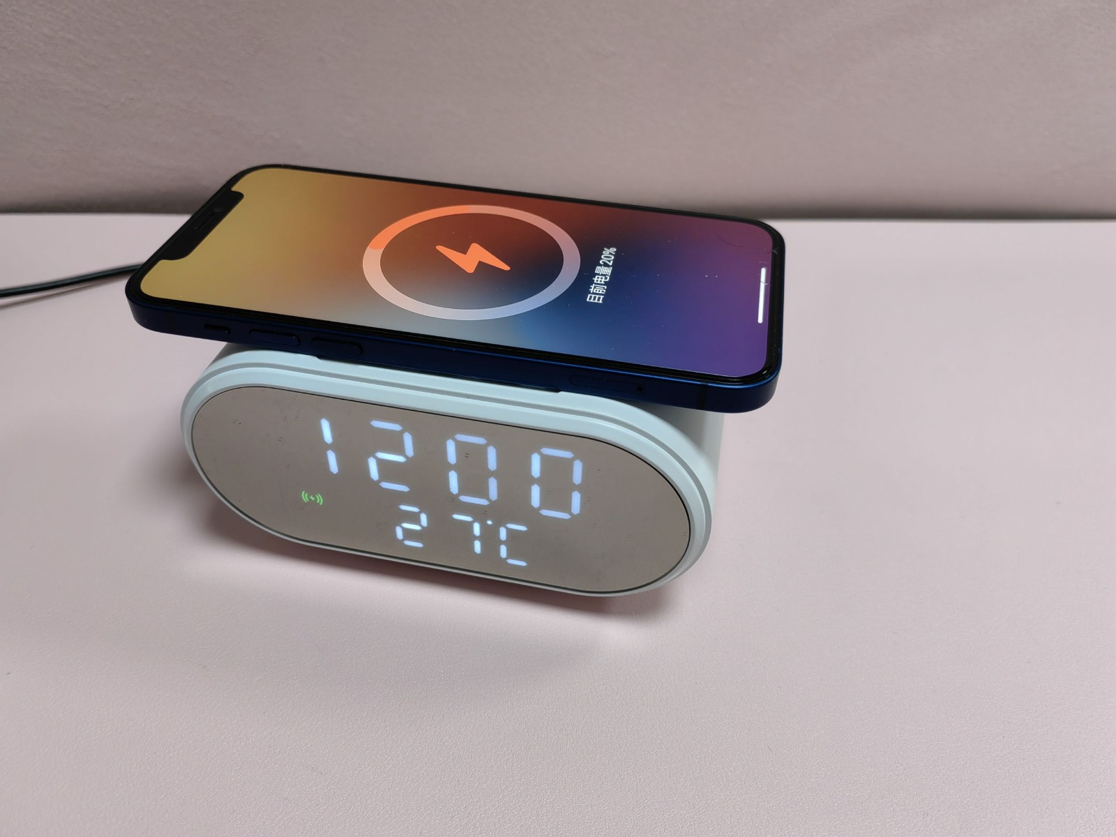 Ein Telefon, das auf einem kabellosen Ladegerät geladen wird. Das Ladegerät ist auch eine Uhr.