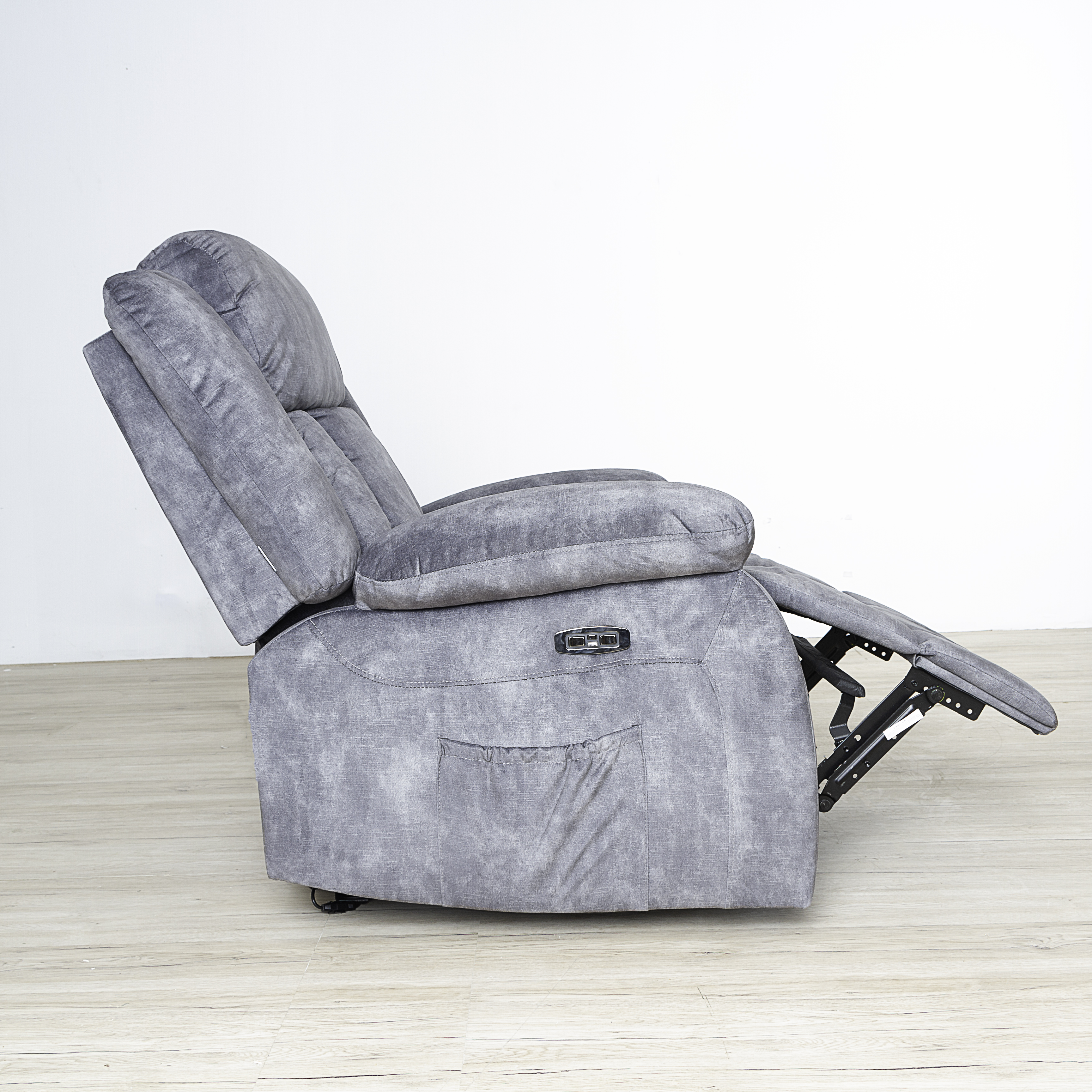 Sillón reclinable gris sobre suelo de madera clara, reposapiés extendido.