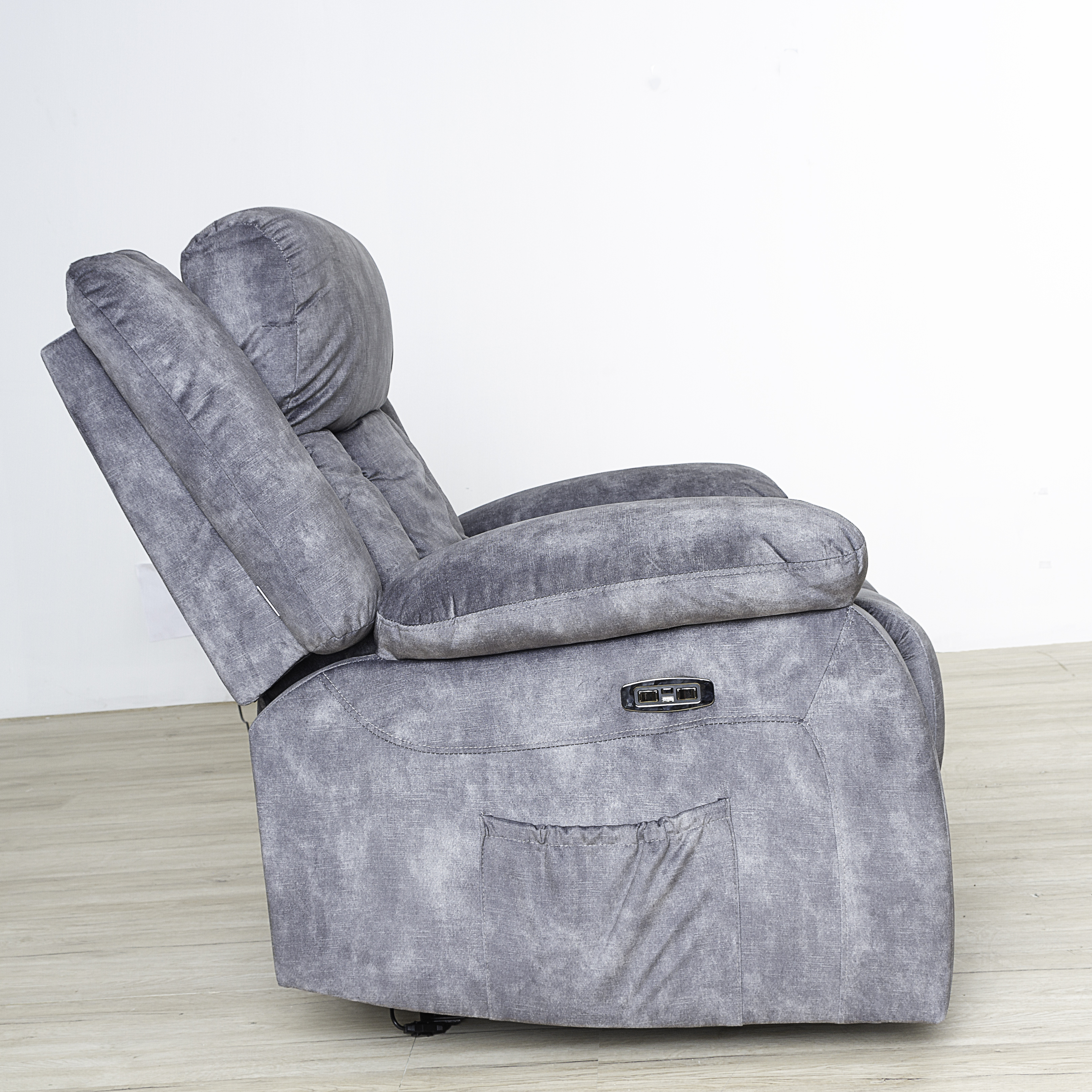 Sillón reclinable gris con bolsillo. La silla está ligeramente reclinada.