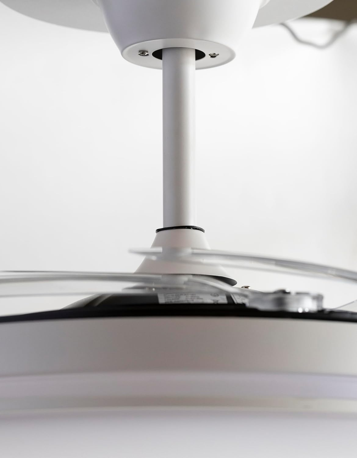 Ventilador de techo con aspas blancas, primer plano.